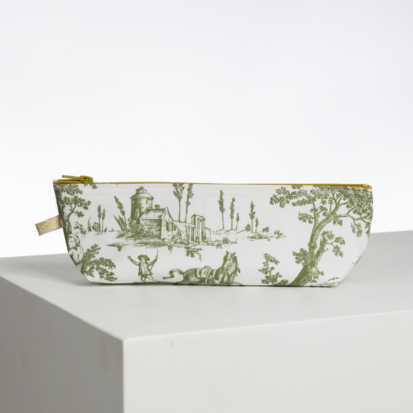Le XCOMM_BIC BALLON PESTO est une pochette blanche à fermeture éclair avec un imprimé de toile pastorale verte - des arbres, un cheval, des personnes et un bâtiment - représenté sur une surface blanche sur un fond uni. la marque Toile de Jouy