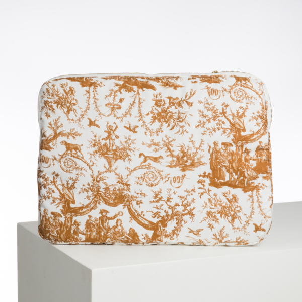 Le XCOMM_BIC BALLON PESTO est une pochette rectangulaire blanche avec un motif de toile or et marron représentant des personnages, des feuillages et des animaux, présentés sur un socle géométrique blanc sur un fond uni. la marque Toile de Jouy