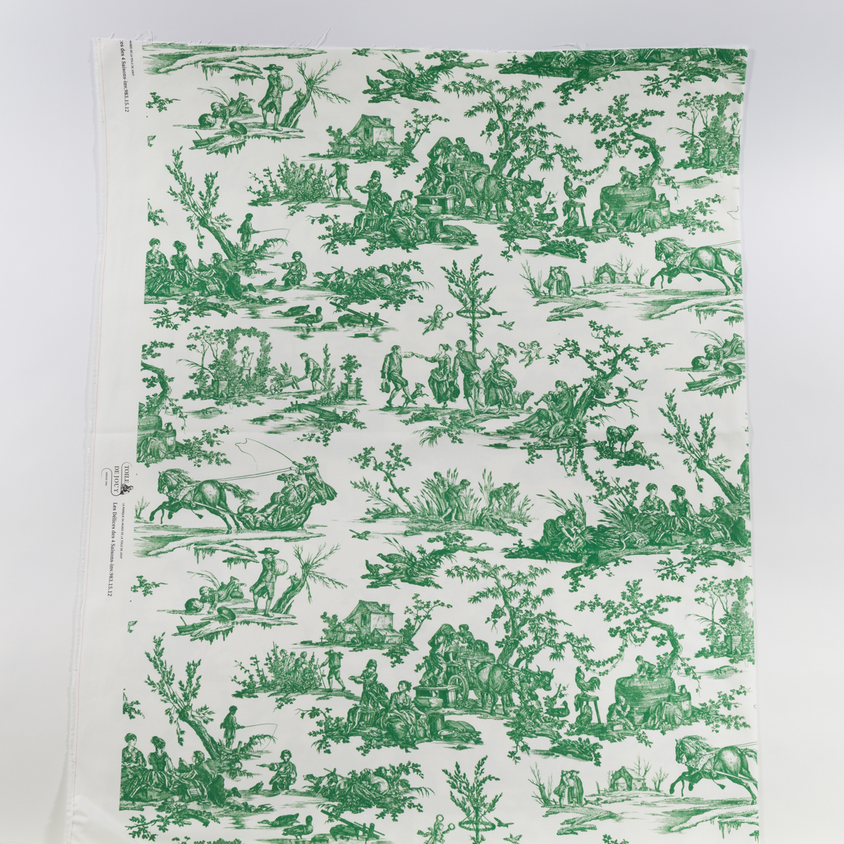 TISSU "LES 4 PARTIES DU MONDE" VERT JUNGLE : Tissu blanc présentant des scènes de jungle vertes détaillées avec des personnes, des animaux et des arbres dans un motif répétitif de style toile classique. la marque Toile de Jouy