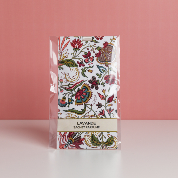 Un lot de sachets parfumés à la lavande « FANTAISIE INDIENNE » de la marque ETIQUETTE DE VOYAGE, ornés d'un motif floral et présentés dans un emballage en plastique transparent, est posé sur une surface blanche devant un fond rose. la marque Toile de Jouy