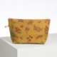 La XCOMM_CAPE DE PLUIE SEMIS DE FLEURS est une pochette jaune à fermeture éclair présentant des motifs floraux roses, rouges, verts et blancs, sur une surface blanche et un fond blanc uni. la marque Toile de Jouy