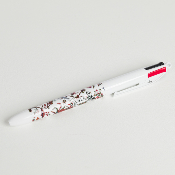Le BIC "ANANAS" est un stylo blanc multicolore avec un motif floral, représenté sur une surface blanche. Le capuchon comporte des languettes de sélection d'encre rouge et noire. la marque Toile de Jouy