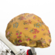 La XCOMM_CAPE DE PLUIE SEMIS DE FLEURS est une housse de selle de vélo jaune avec un motif floral coloré de fleurs roses, bleues et vertes, montrée installée sur une selle de vélo avec une partie du cadre blanc visible. la marque Toile de Jouy