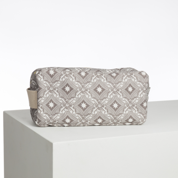 Le XCOMM_LUNCH BAG ESCARPOLETTE ROUGE est un sac à lunch rectangulaire en tissu à motif géométrique gris et blanc, doté d'une poignée latérale. Il est représenté sur une surface blanche sur un fond uni. la marque Toile de Jouy