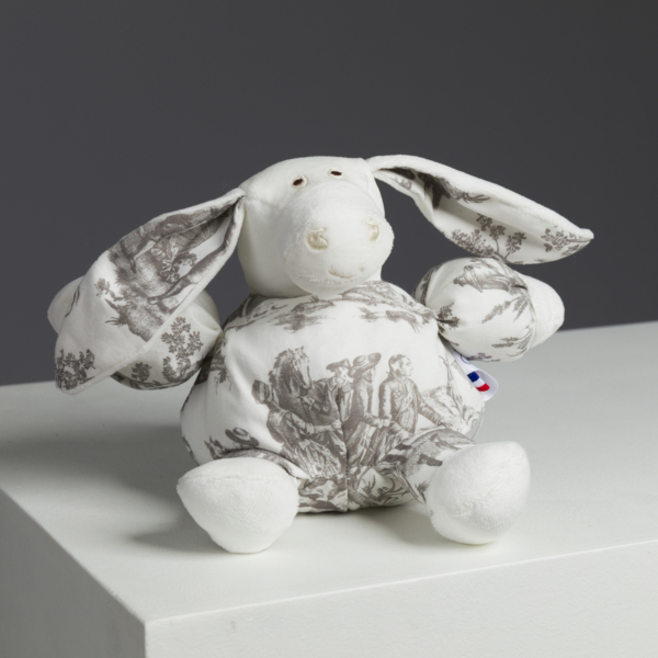 Le sac XCOMM_LUNCH BAG ESCARPOLETTE ROUGE, réalisé en tissu blanc avec un motif de toile pastorale grise, est présenté sur une surface blanche avec un fond gris. la marque Toile de Jouy