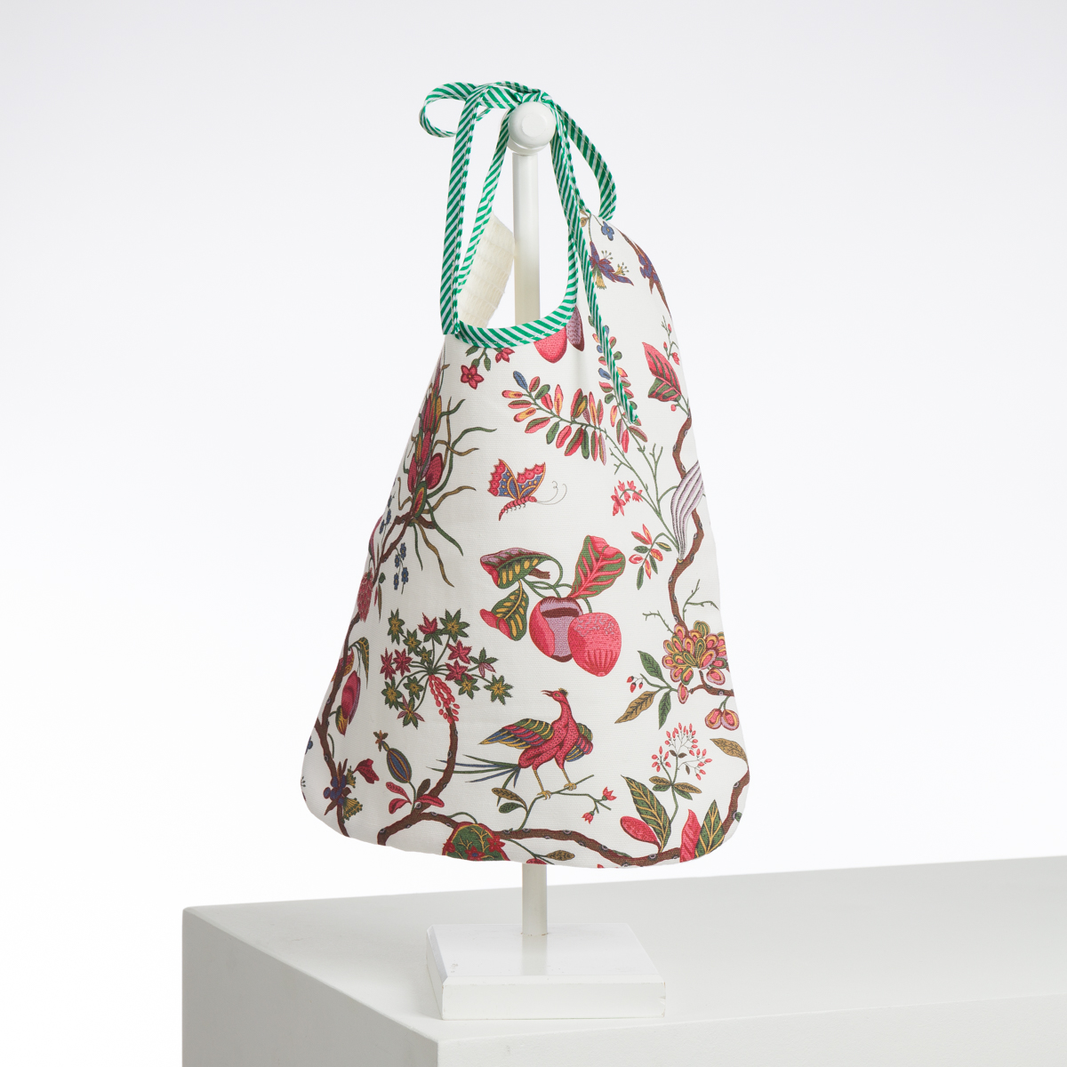 ABAT-JOUR SUR COMMANDE : Un abat-jour conique en tissu sur pied avec un imprimé floral et d'oiseaux vibrant, des cordons rayés verts et blancs, le tout sur un fond blanc minimaliste. la marque Toile de Jouy