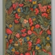 Le carnet XCOMM_CARNET A5 BLEUETS présente une couverture avec un motif floral dense et coloré représentant des fleurs rouges, jaunes, bleues et roses avec des feuilles vertes sur un fond sombre. la marque Toile de Jouy