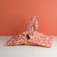 Le XCOMM_SET DE TABLE /2 FLEURS STYLISEES MANDARINE présente des motifs floraux stylisés orange et blancs, sur une surface blanche à fond orange. Ses poignées droites et son design doux et déstructuré créent un look décontracté. la marque Toile de Jouy