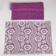 Un XCOMM_SET DE TABLE /2 FLEURS STYLISEES SAUGE plié se trouve au-dessus d'une pièce rectangulaire avec un motif floral blanc et de la dentelle, tous deux présentés sur un fond blanc. la marque Toile de Jouy