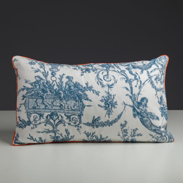 Le XCOMM_COUSSIN 30X50 ESCARPOLETTE BLEU est un coussin rectangulaire blanc orné de motifs vintage « toile de Jouy » bleus, mettant en valeur des dessins et des figures complexes. Il est rehaussé d'un passepoil orange sur les bords et se détache sur un fond sombre, sur une surface claire. la marque Toile de Jouy