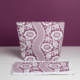 La « XCOMM_GRANDE TROUSSE DE TOILETTE FLEURS AMARANTE », composée d'une pochette à fermeture éclair et d'un accessoire en tissu assorti orné d'un motif de dentelle florale violette et blanche, est présentée sur un fond violet avec une petite étiquette attachée. la marque Toile de Jouy