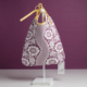 Le modèle XCOMM_BAVOIR 4 APRTIES AMARANTE, orné d'un motif floral violet et blanc, est présenté sur un présentoir blanc orné d'un ruban jaune noué en haut, sur fond violet. Une petite étiquette est accrochée dans le coin inférieur droit du sac. la marque Toile de Jouy