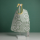 Un « XCOMM_TROUSSE STYLOS OFFRANDE SAUGE » est présenté sur un présentoir blanc, devant un fond vert. la marque Toile de Jouy