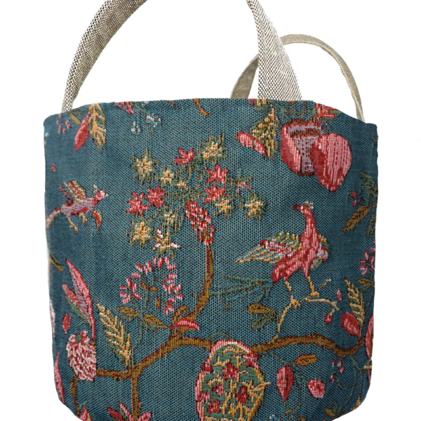 GPA2572T_1 Panier en tissu muni de deux anses, orné d'un motif complexe de tapisserie représentant des fleurs et des oiseaux dans les tons rose, vert et bleu sur un fond bleu sarcelle. la marque Toile de Jouy