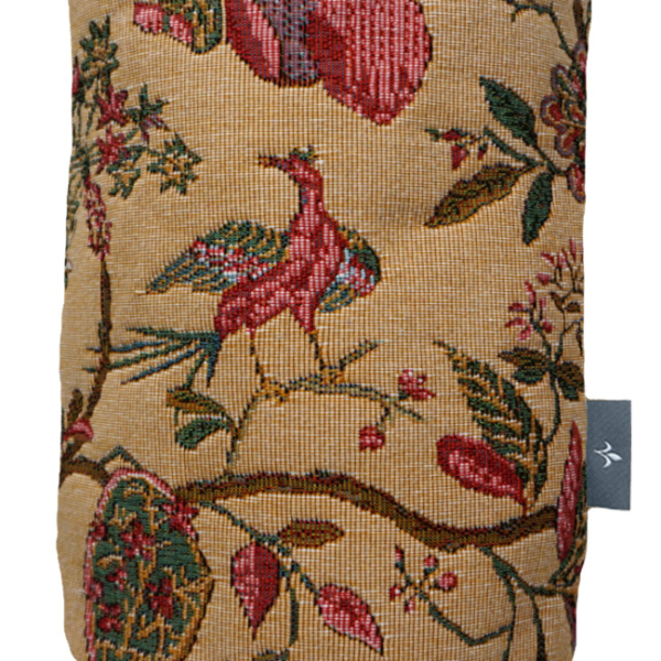 PA2572J_1 Un sac cylindrique en tissu sur fond beige, orné d'un motif de tapisserie très travaillé représentant des oiseaux, des feuilles et des fleurs colorés dans des tons de rouge, de vert et de rose. Une petite étiquette grise est fixée sur le côté. la marque Toile de Jouy