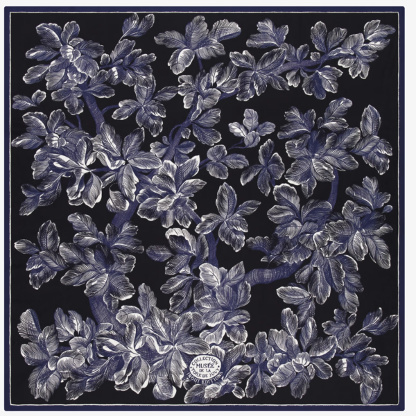 INOUI Des branches feuillues aux motifs complexes, blancs et bleus, occupent tout un fond carré sombre. Une étiquette ronde, située vers le bas au centre, porte l’inscription « Collection Musée Hermès Paris ». la marque Toile de Jouy