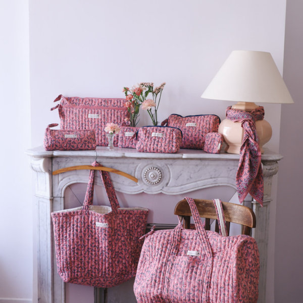 FLO_FRA(2) Une collection de sacs matelassés à motifs floraux de différentes tailles, comprenant des pochettes, un sac cabas et un sac de week-end, disposés sur et autour du manteau d'une cheminée. la marque Toile de Jouy