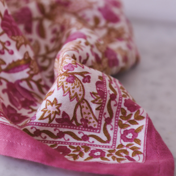FOR_BLU Serviette en tissu pliée, ornée d'un motif floral imprimé en blocs de couleur rose et marron. la marque Toile de Jouy